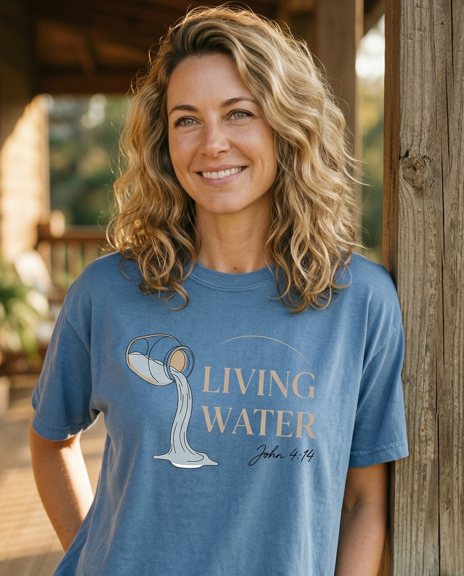 Living Water Flow – Blue Jean women's Christian tee, lifestyle photo in sunny porch – Minimalist line-art design of a clay jar tipping and pouring flowing w – John 4:14 – She Wears Faith