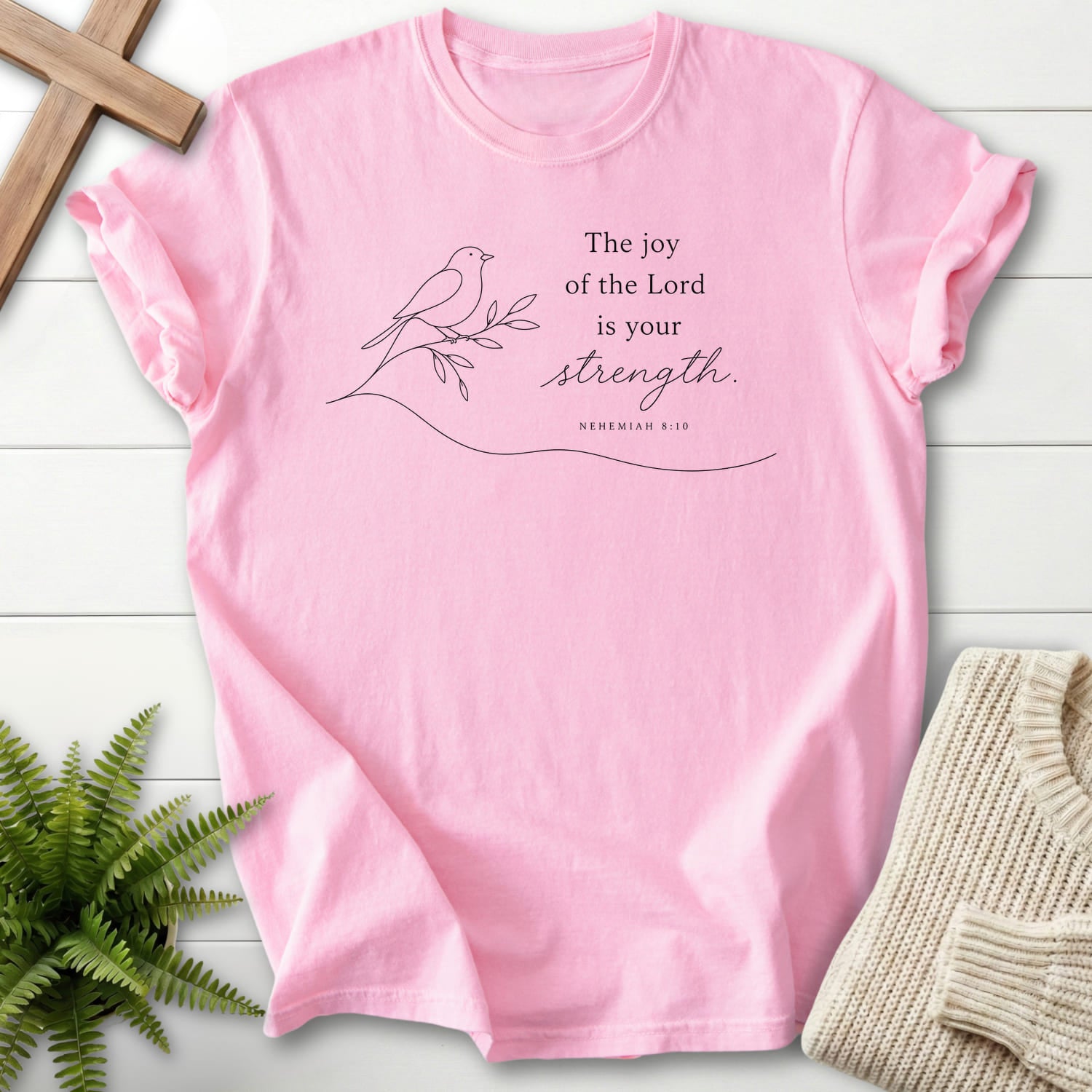 Flat lay of a Blossom garment-dyed Christian tee featuring minimalist design with "Lord is your Strength T-Shirt" Nehemiah 8:10.