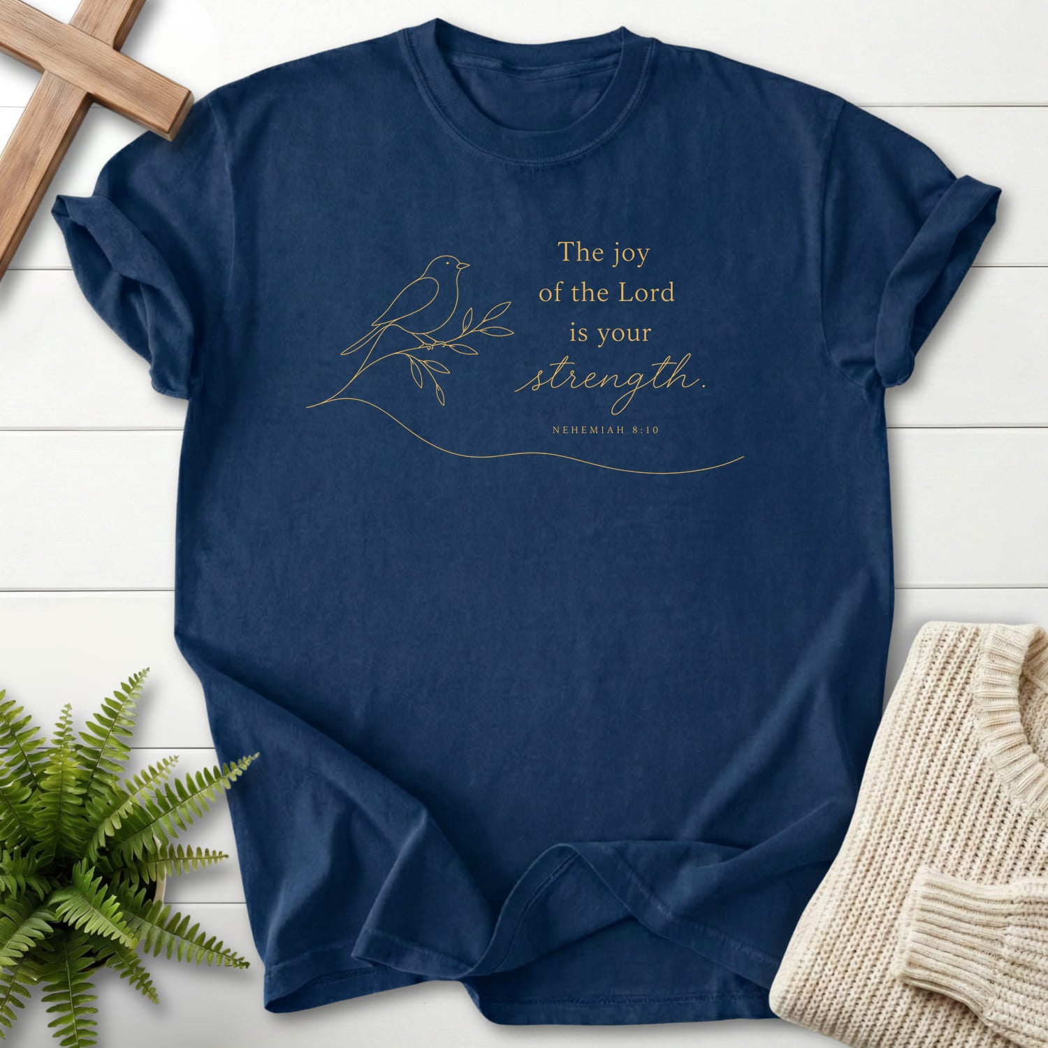Flat lay of a Navy faith-inspired shirt featuring minimalist design with "Lord is your Strength T-Shirt" Nehemiah 8:10.