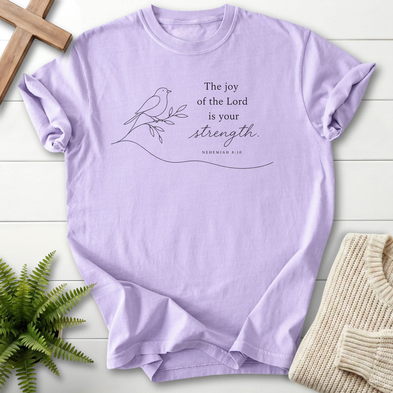 Flatlay of an Orchid Christian shirt with minimalist design with "Lord is your Strength T-Shirt" Nehemiah 8:10.