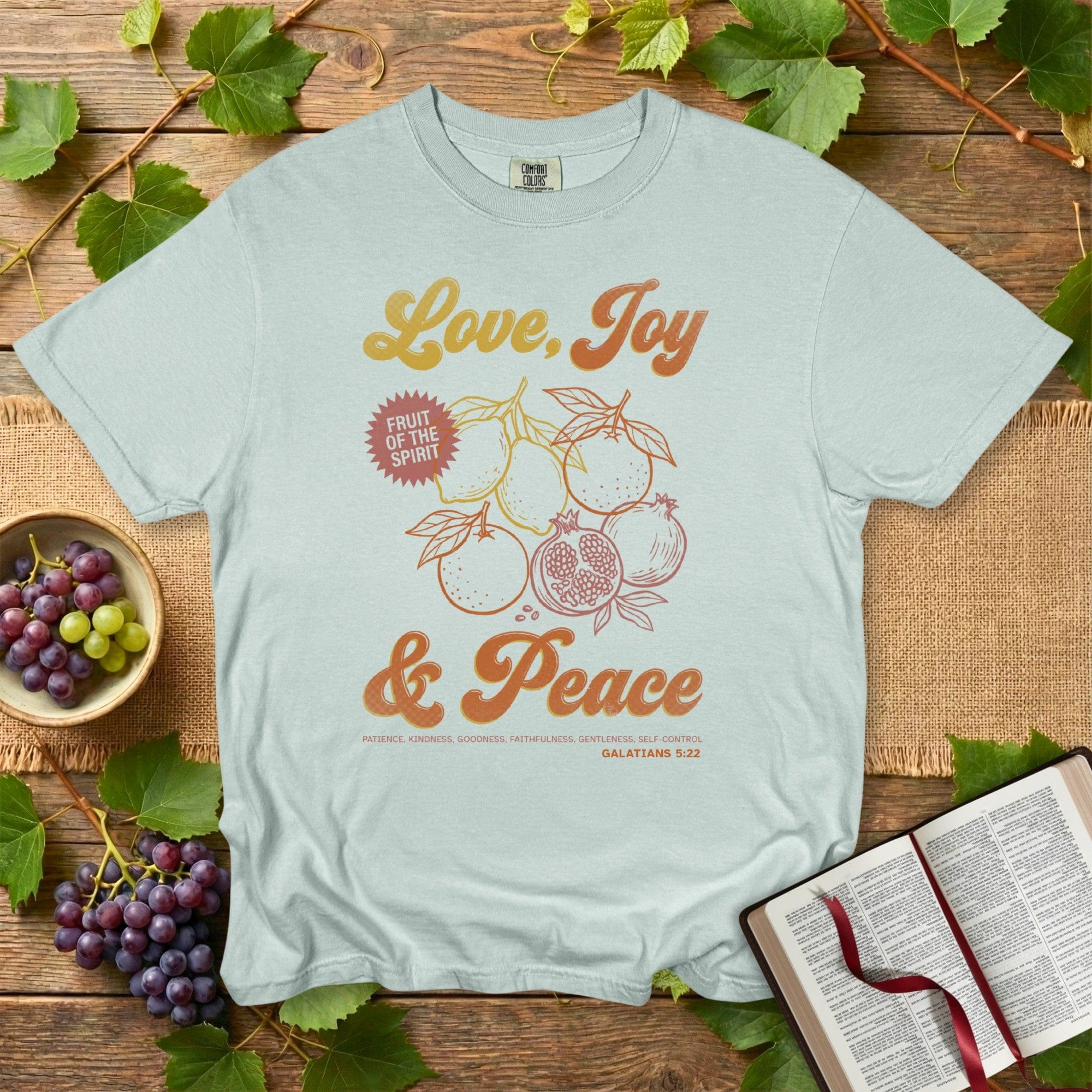 Comfort Colors 1717 bay Christian women tshirt with Fruit of the Spirit artwork and the phrase Love, Joy & Peace from Galatians 5:22. Minimal vintage Christian design perfect for everyday US faith wear
