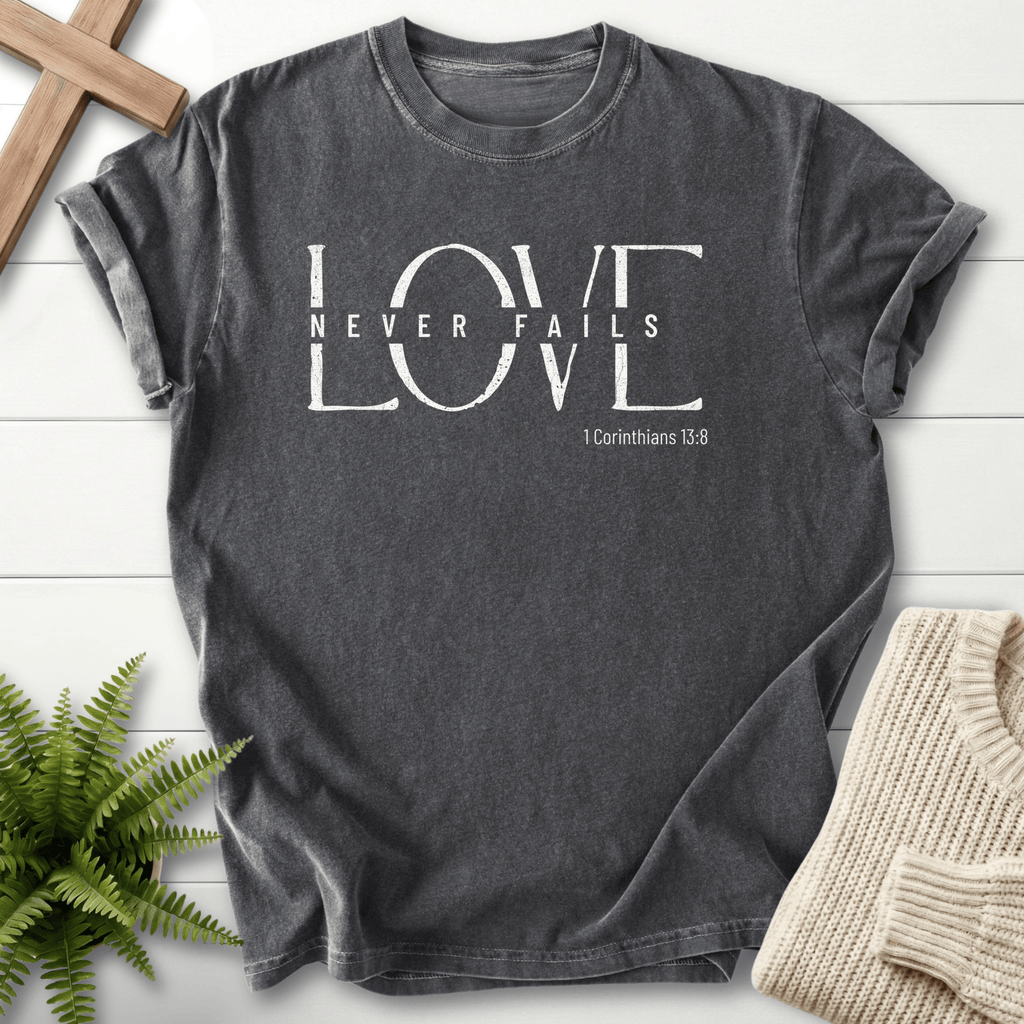 Pepper garment-dyed Christian t-shirt with distressed "Love Never Fails" typography, inspired by 1 Corinthians 13:8.