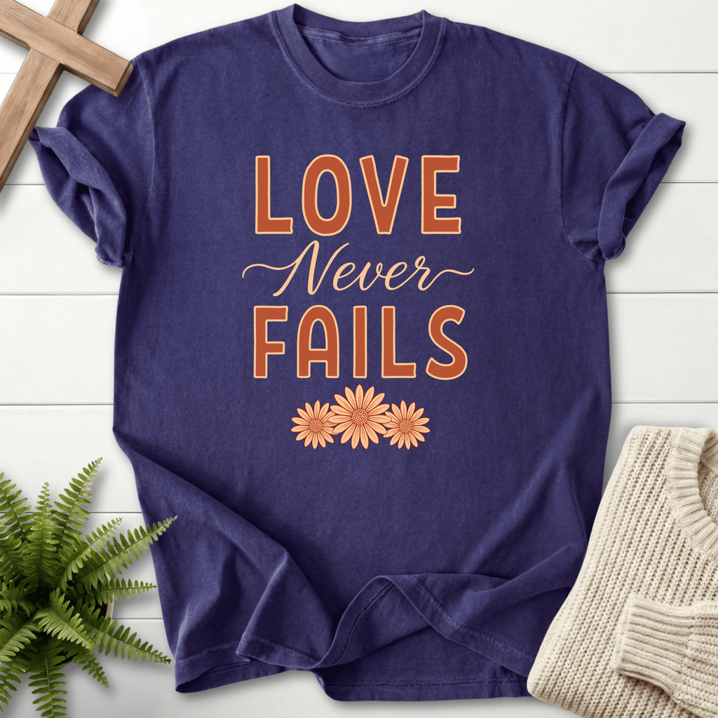 Grape women's faith t-shirt with bold text and daisy flowers, inspired by 1 Corinthians 13:8.