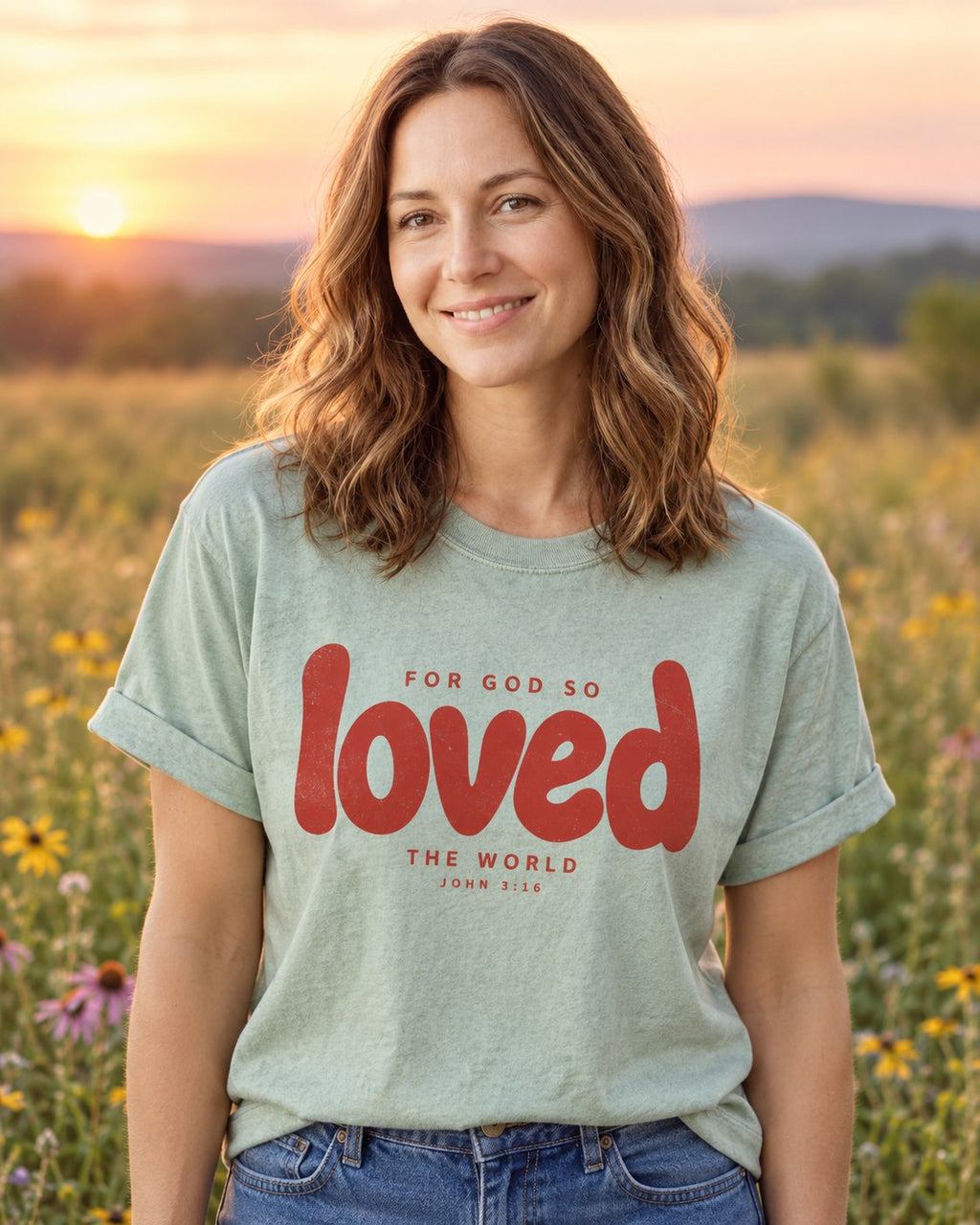 Loved John 3:16, Bay women's Christian tee, lifestyle photo in wildflower meadow, Bubble lettering of loved For God So Loved The World, She Wears Faith