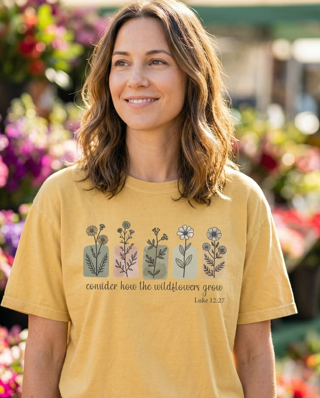 Luke 12:27 Wildflower – Butter women's Christian tee, lifestyle photo in farmers market – Five watercolor wildflower stems in illustrated vases or blocks in mut – Luke 12:27 – She Wears Faith