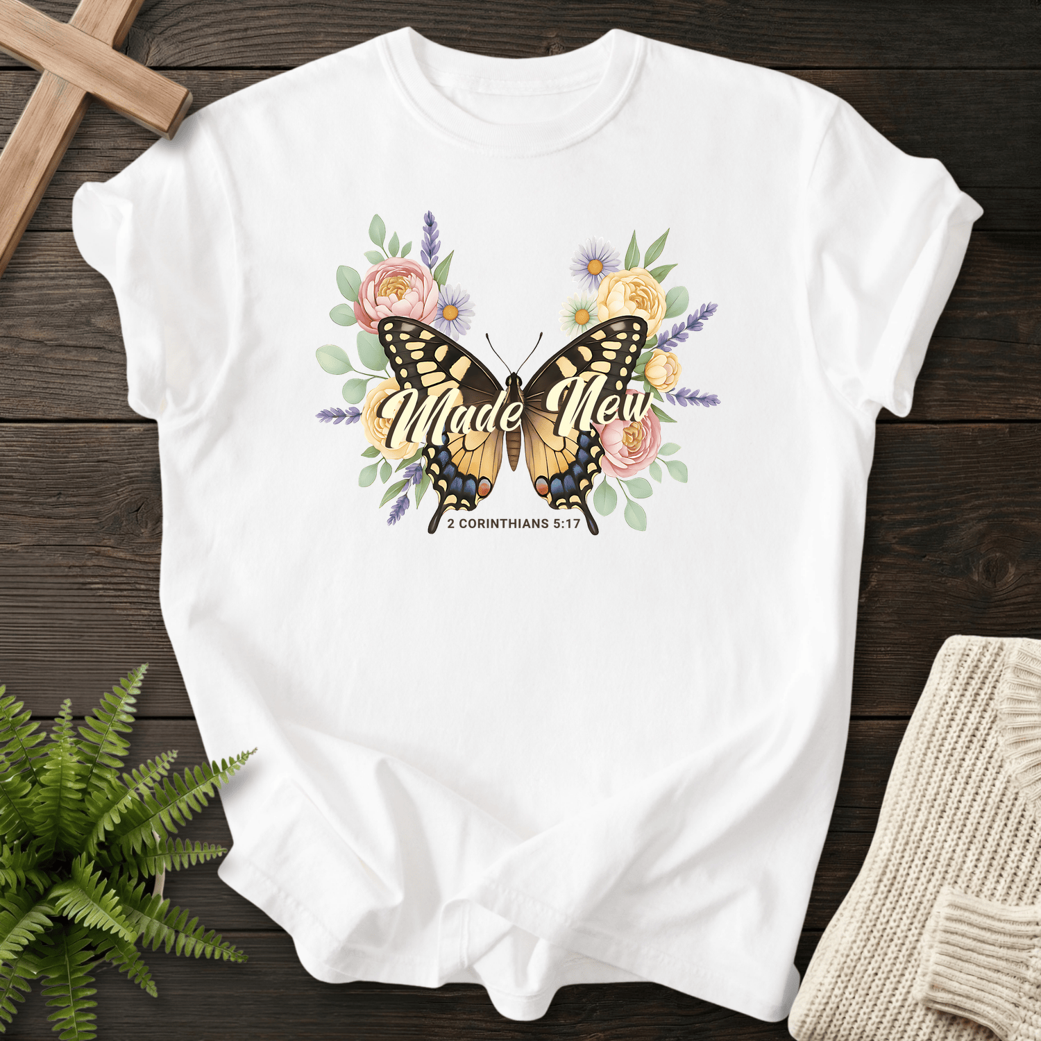 White women's Scripture shirt with watercolor butterfly and floral illustration, inspired by 2 Corinthians 5:17.