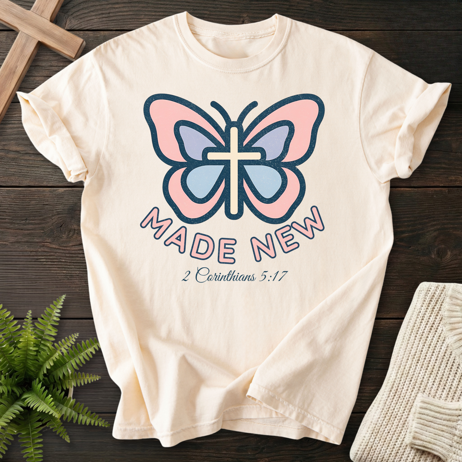 Ivory women's Christian t-shirt with pastel cross butterfly design, inspired by 2 Corinthians 5:17.