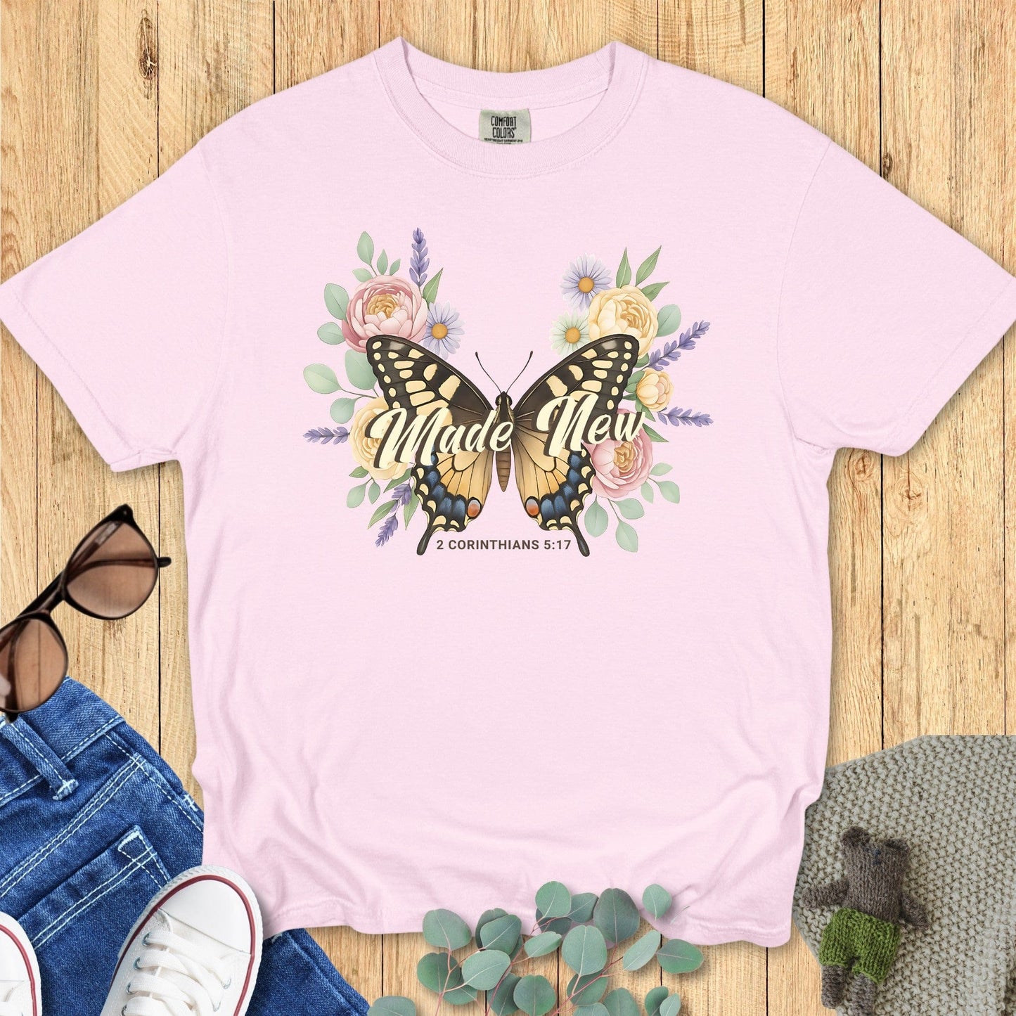 Comfort Colors 1717 blossom “Made New – 2 Corinthians 5:17” t-shirt with butterfly and pastel flower design symbolizing new life. A soft and feminine women’s scripture tee — inspiring faith-based apparel for women and thoughtful Christian mom gift.