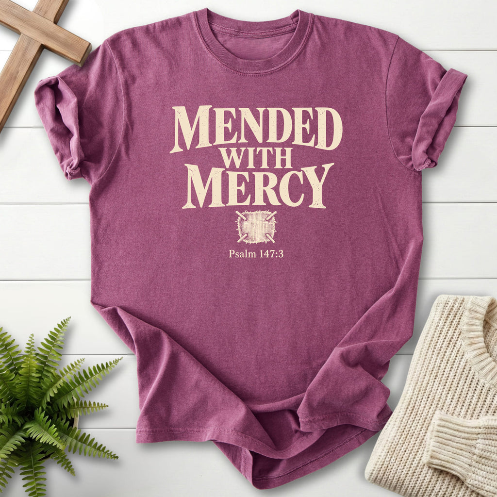 Flat lay of a Berry Bible verse tee featuring "Mended with Mercy T-Shirt" Psalm 147:3.