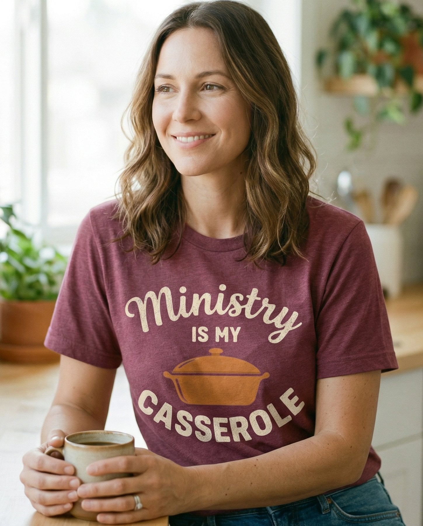 Ministry is My Casserole – Berry women's Christian tee, lifestyle photo in morning kitchen setting – Script and block lettering reading 'Ministry is My Casserole' with a c – She Wears Faith