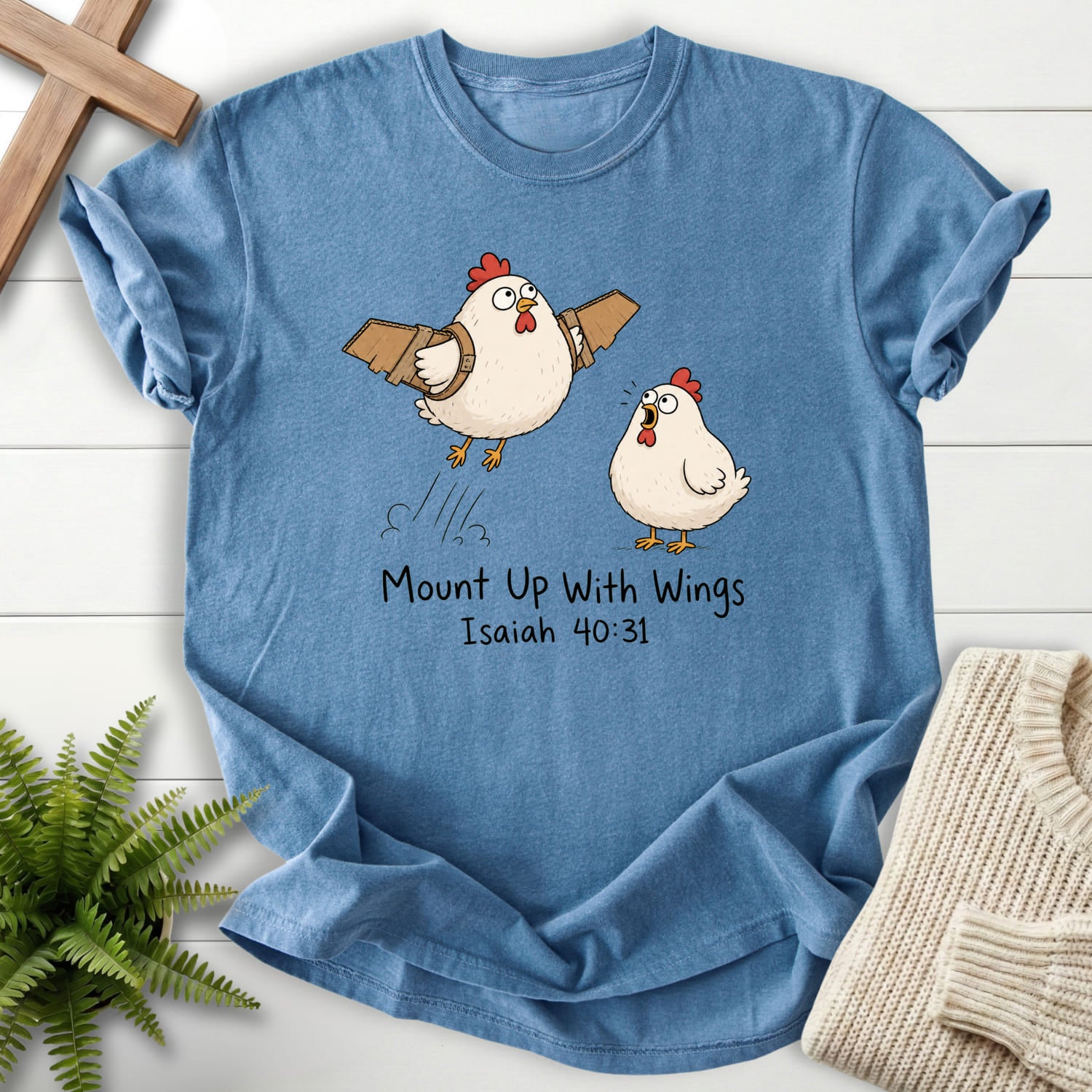 Flatlay of a Blue Jean faith-inspired shirt with "Mount Up With Wings Isaiah 40:31 T-Shirt" Isaiah 40:31.