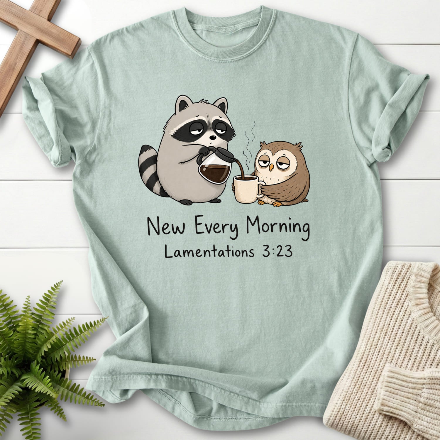 Flat lay of a Bay Christian t-shirt for women featuring "New Every Morning Raccoon Owl T-Shirt" Lamentations 3:23 From Printify.