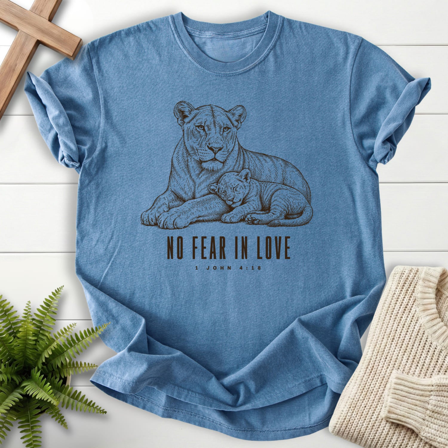 Flatlay of a Blue Jean Christian graphic tee with "No Fear in Love T-Shirt" 1 John 4:18.