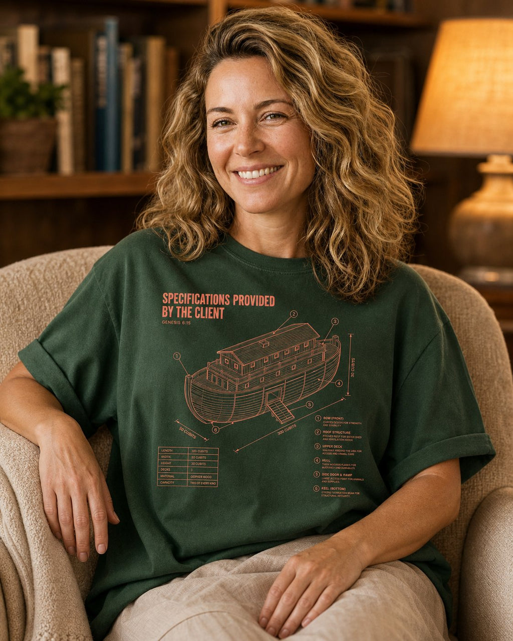 Noahs Ark Blueprint Genesis 6:15 – Hemp women's Christian tee, lifestyle photo in cozy reading nook – Technical blueprint of Noah's ark with labelled specifications – Genesis 6:15 – She Wears Faith