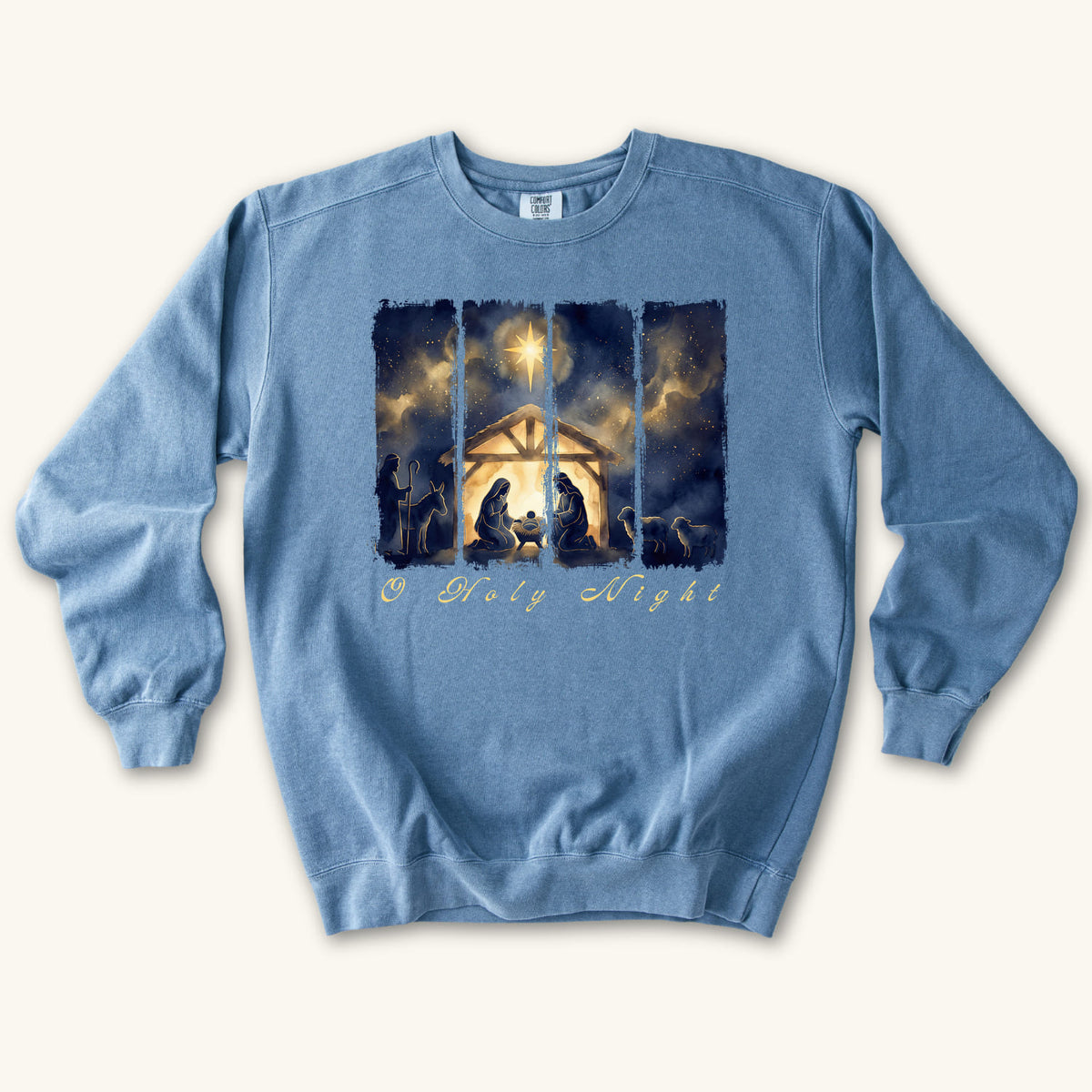 Blue Jean Christian Christmas sweatshirt with a painted nativity of Mary, Joseph and the manger in a glowing stable under a bright star, with O Holy Night in script.