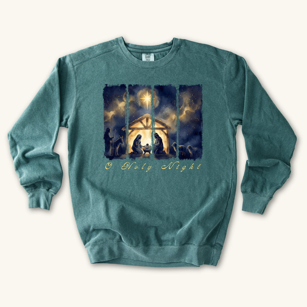 Blue Spruce Christian Christmas sweatshirt with a painted nativity of Mary, Joseph and the manger in a glowing stable under a bright star, with O Holy Night in script.