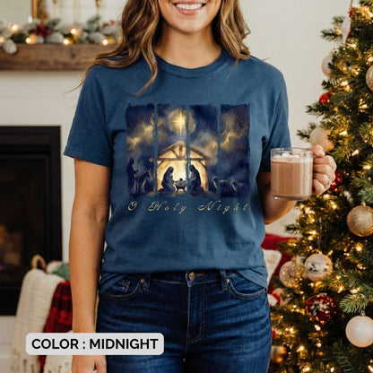 lifestyle model of women wearing Comfort Colors 1717 midnight Christian T-shirt displaying a rich watercolor “O Holy Night” manger scene with the Holy Family, shepherds, and glowing star. A beautiful Christmas US faith wear tee arranged with rustic holiday décor.