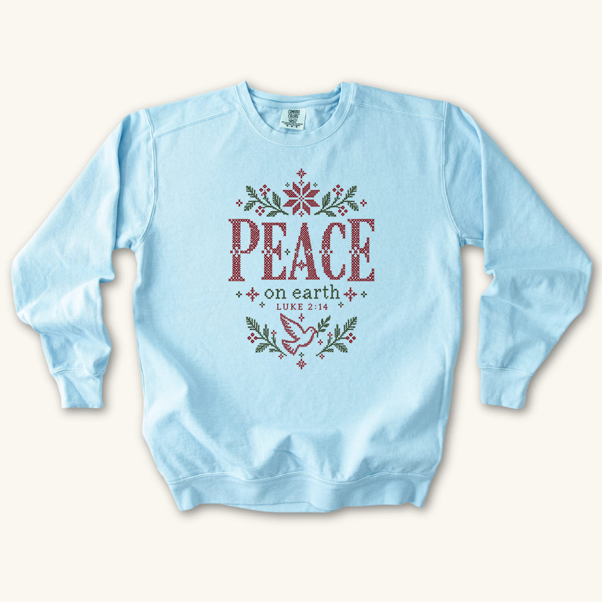 Chambray Christian Christmas sweatshirt with cross-stitch style Peace on Earth lettering, a dove, stars, branches and Luke 2:14.