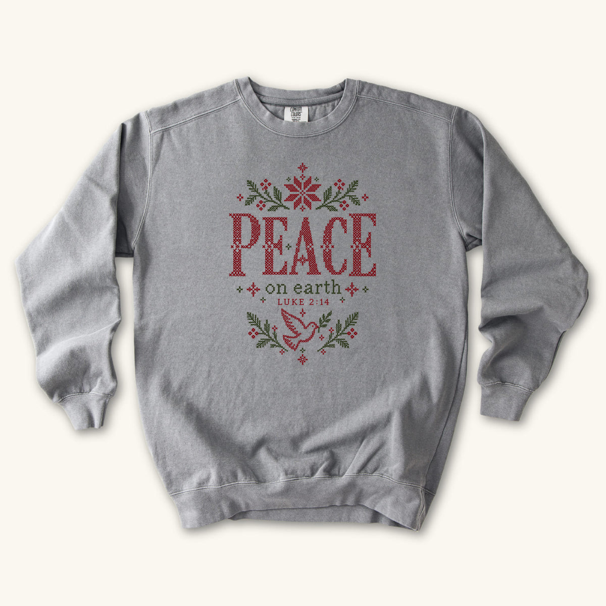 Grey Christian Christmas sweatshirt with cross-stitch style Peace on Earth lettering, a dove, stars, branches and Luke 2:14.