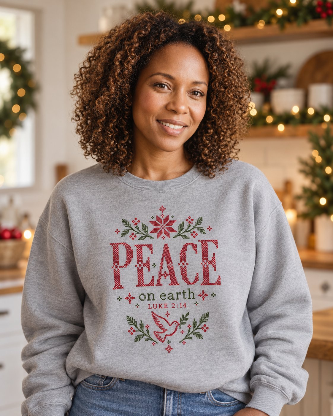 Peace on Earth, Grey women's Christian sweatshirt, lifestyle photo in cozy holiday setting, Cross-stitch PEACE on earth with poinsettia and dove, She Wears Faith