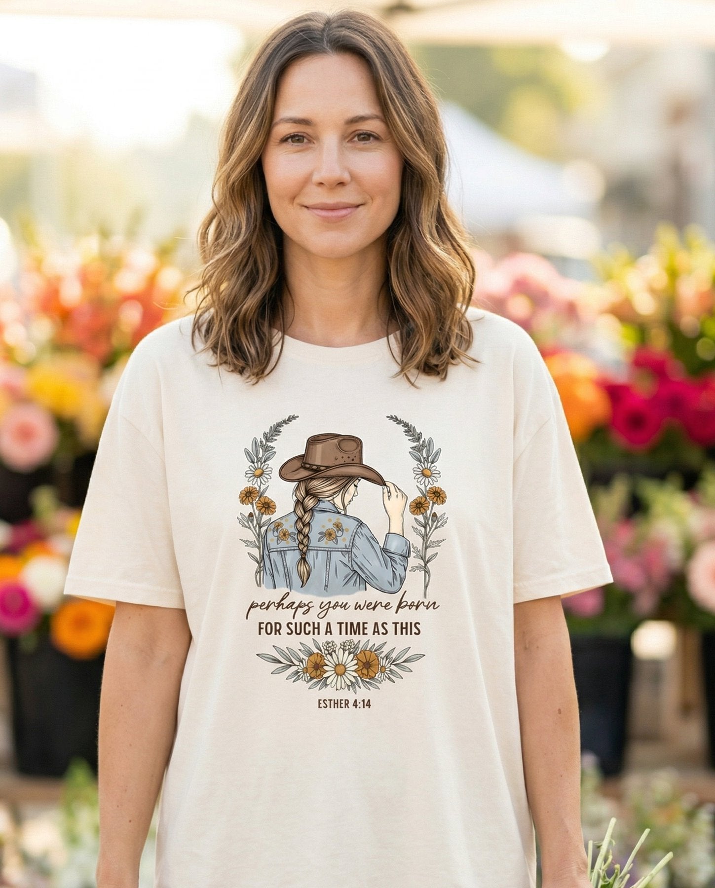 Perhaps You Were Born – Ivory women's Christian tee, lifestyle photo in farmers market – Illustrated woman in a cowboy hat seen from behind with a long braid – Esther 4:14 – She Wears Faith