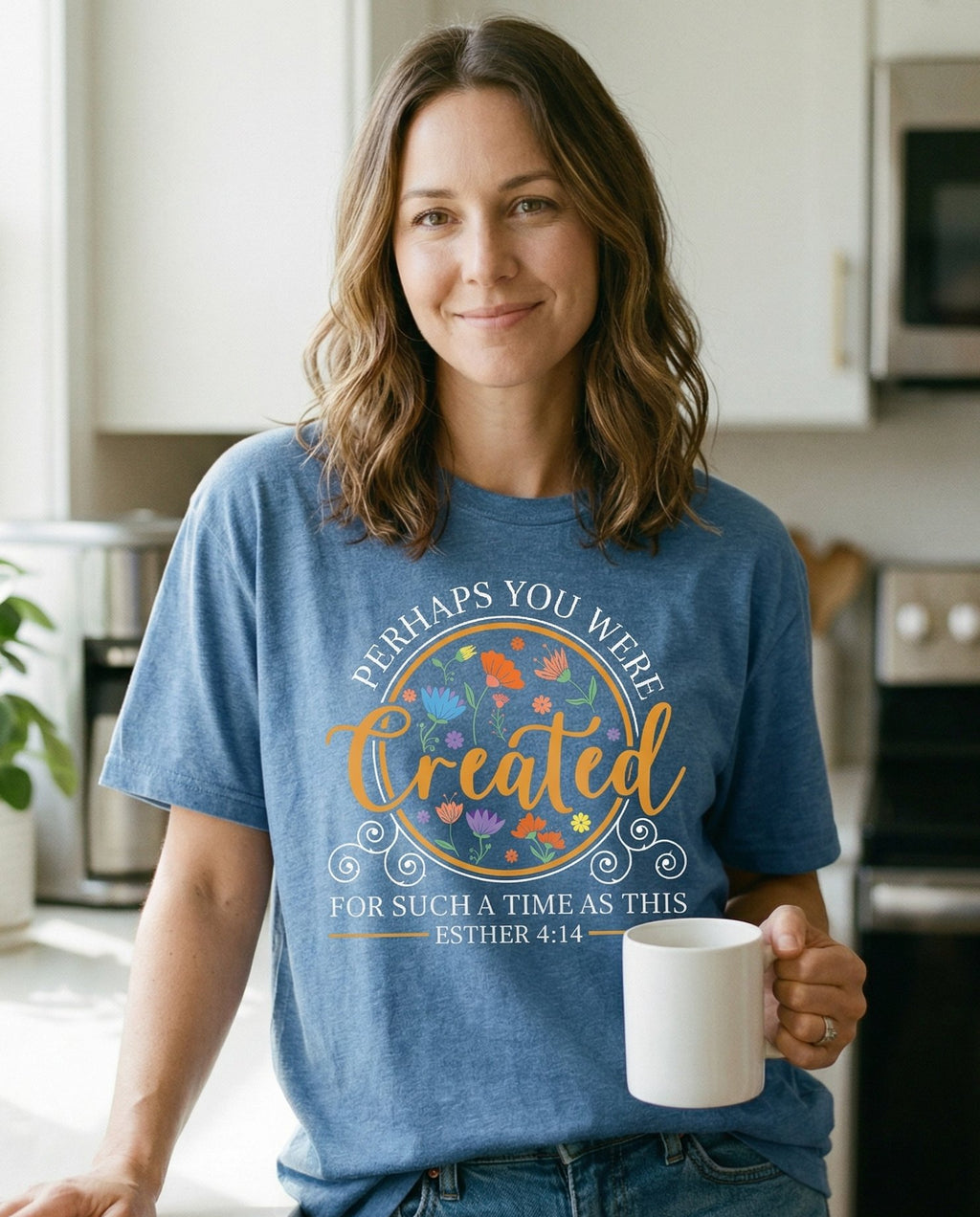Created for Such a Time as This – Blue Jean women's Christian tee, lifestyle photo in morning kitchen setting – Circular badge design with colorful wildflower illustrations and ornat – Esther 4:14 – She Wears Faith