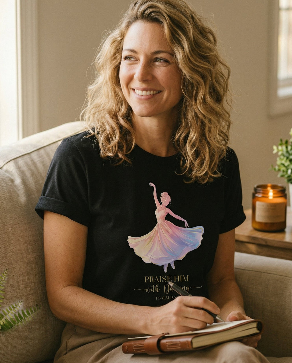 Praise Him with Dancing – Black women's Christian tee, lifestyle photo in cozy living room – Watercolor illustration of a woman in a flowing rainbow dress with arm – Psalm 149:3 – She Wears Faith