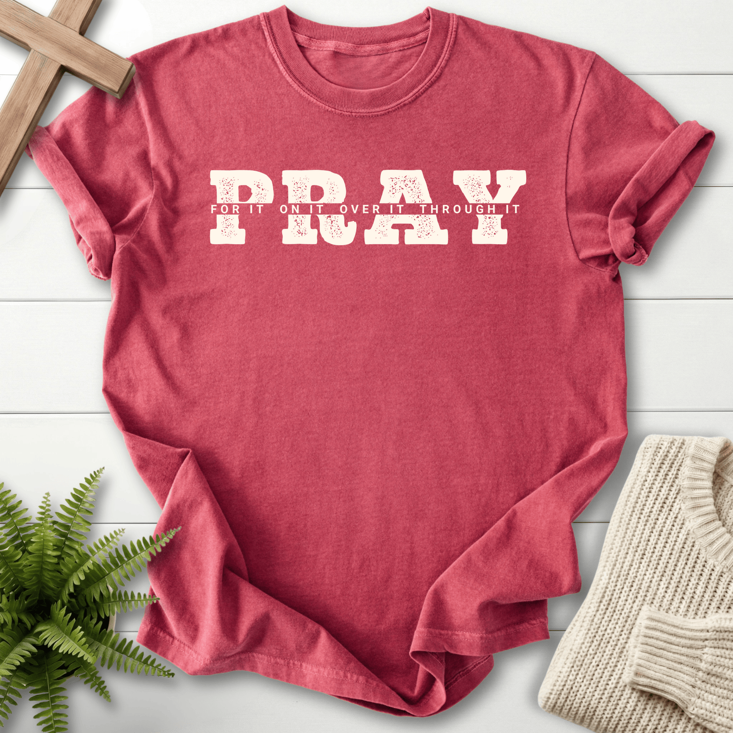 Crimson women's Christian t-shirt with bold white "PRAY" block design and "For It, On It, Over It, Through It" text.