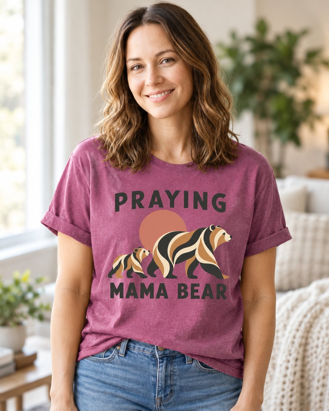 Praying Mama Bear, Berry women's Christian tee, lifestyle photo in cozy living room, geometric mama bear and cub with PRAYING MAMA BEAR, She Wears Faith