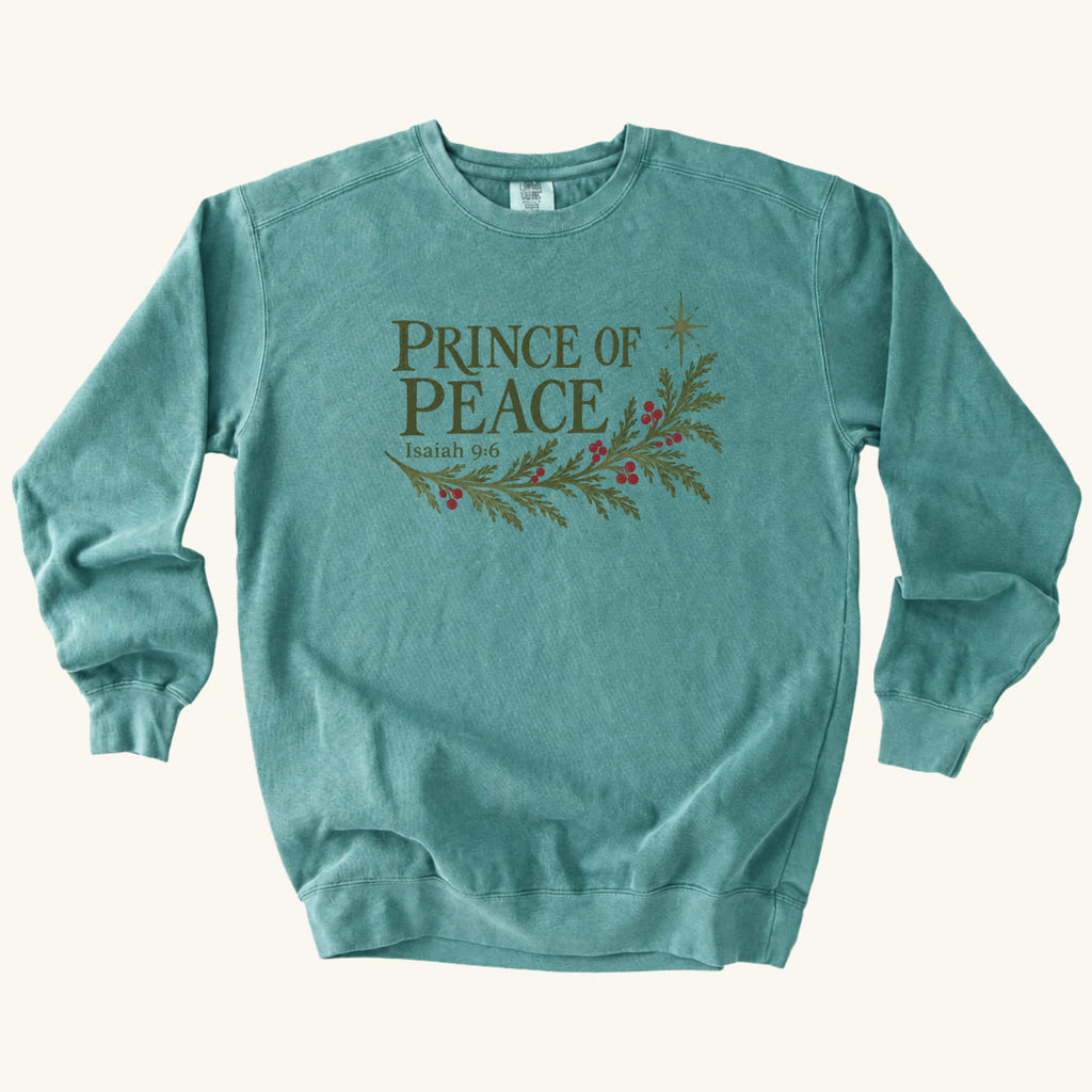 Seafoam Christian Christmas sweatshirt with Prince of Peace lettering, an evergreen branch with red berries, a star and Isaiah 9:6.