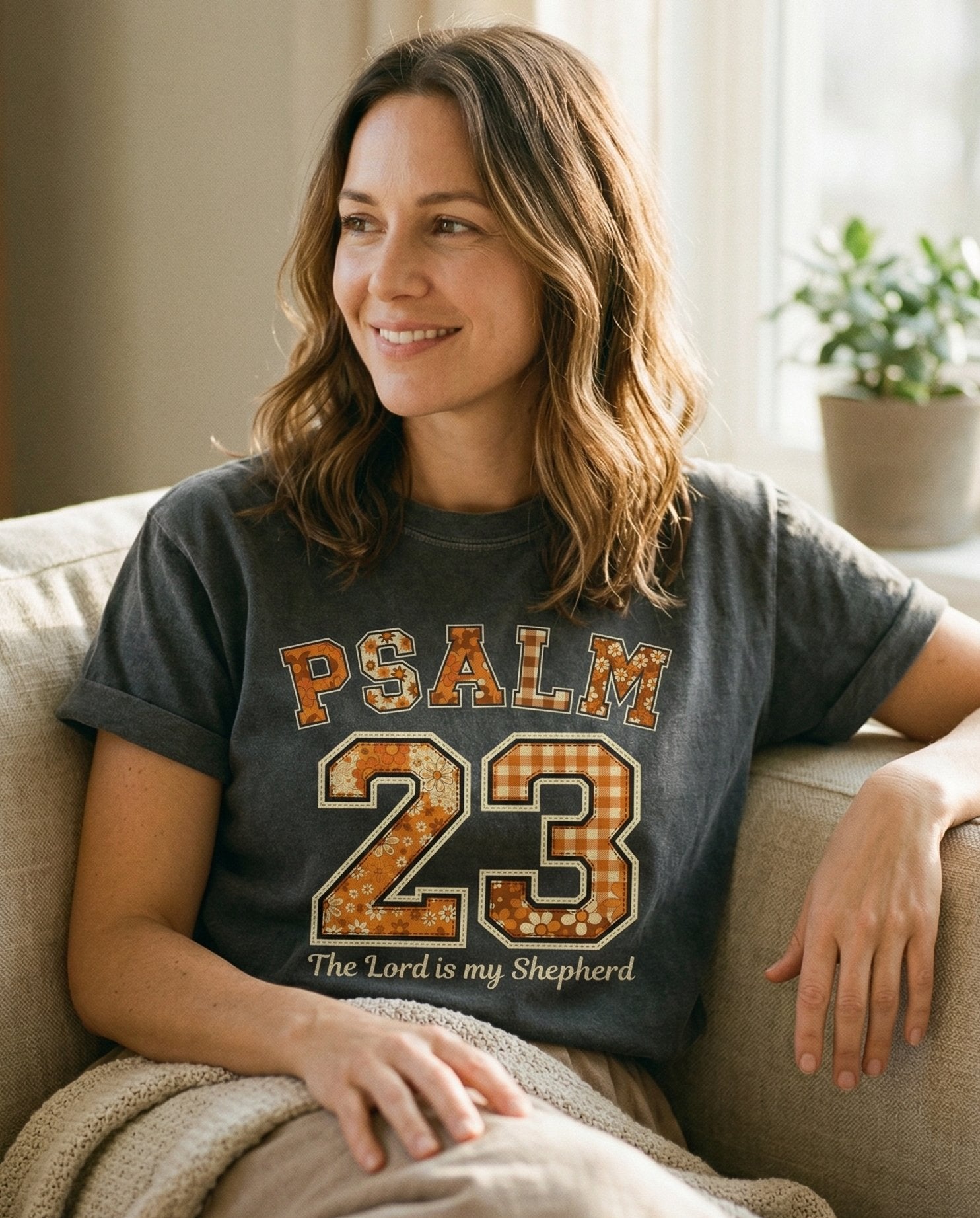 Psalm 23 Patchwork – Pepper women's Christian tee, lifestyle photo in cozy living room – Varsity-style PSALM 23 lettering in patchwork floral and gingham fabri – Psalm 23 – She Wears Faith
