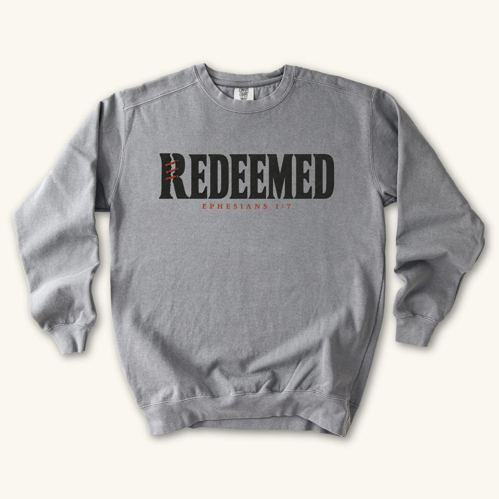 Grey Redeemed sweatshirt flat lay mockup, Ephesians 1:7 Christian apparel for women