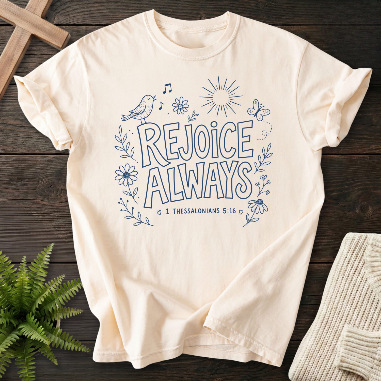 Flat lay of an Ivory Comfort Colors 1717 Bible verse tee featuring butterfly artwork with "Rejoice Always T-Shirt" 1 Thessalonians 5:16.