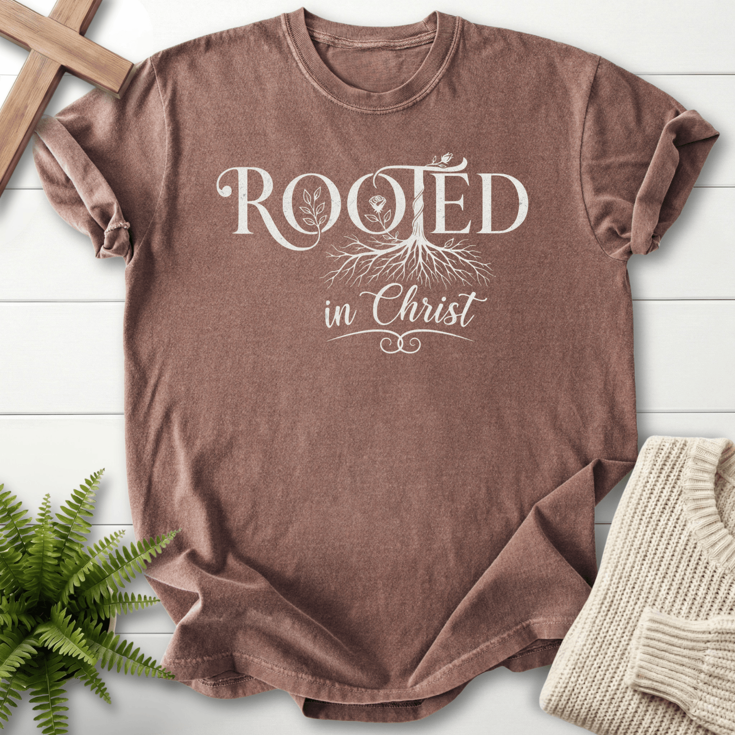 Espresso women's faith t-shirt with white Rooted in Christ tree and root graphic.
