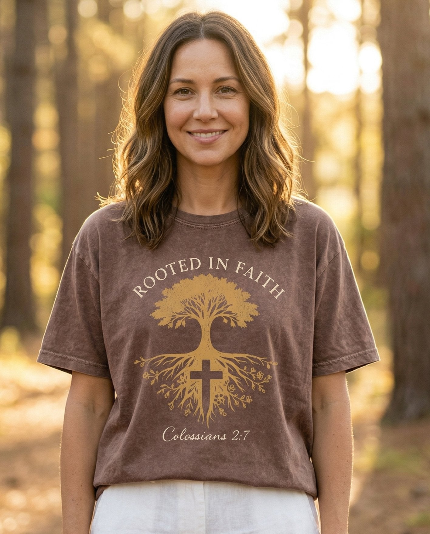 Rooted in Faith – Espresso women's Christian tee, lifestyle photo in nature trail – Golden tree-of-life graphic with deep roots and a cross at the base – Colossians 2:7 – She Wears Faith