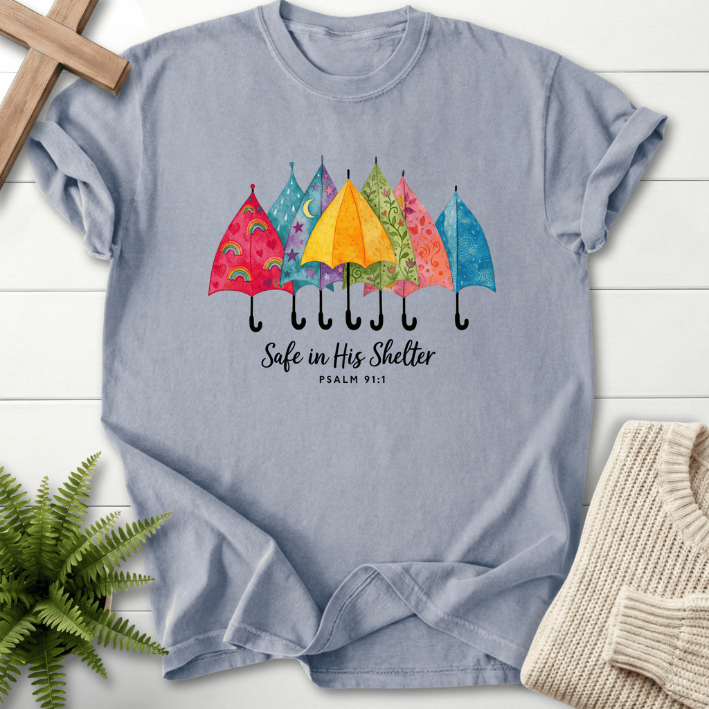 Granite women's Scripture shirt with a row of colorful umbrellas and "Safe in His Shelter," inspired by Psalm 91:1.