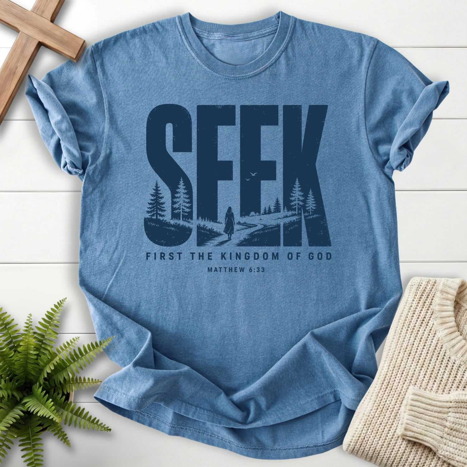 Flatlay of a Blue Jean women's Christian tee with "Seek First the Kingdom of God T-Shirt" Matthew 6:33.
