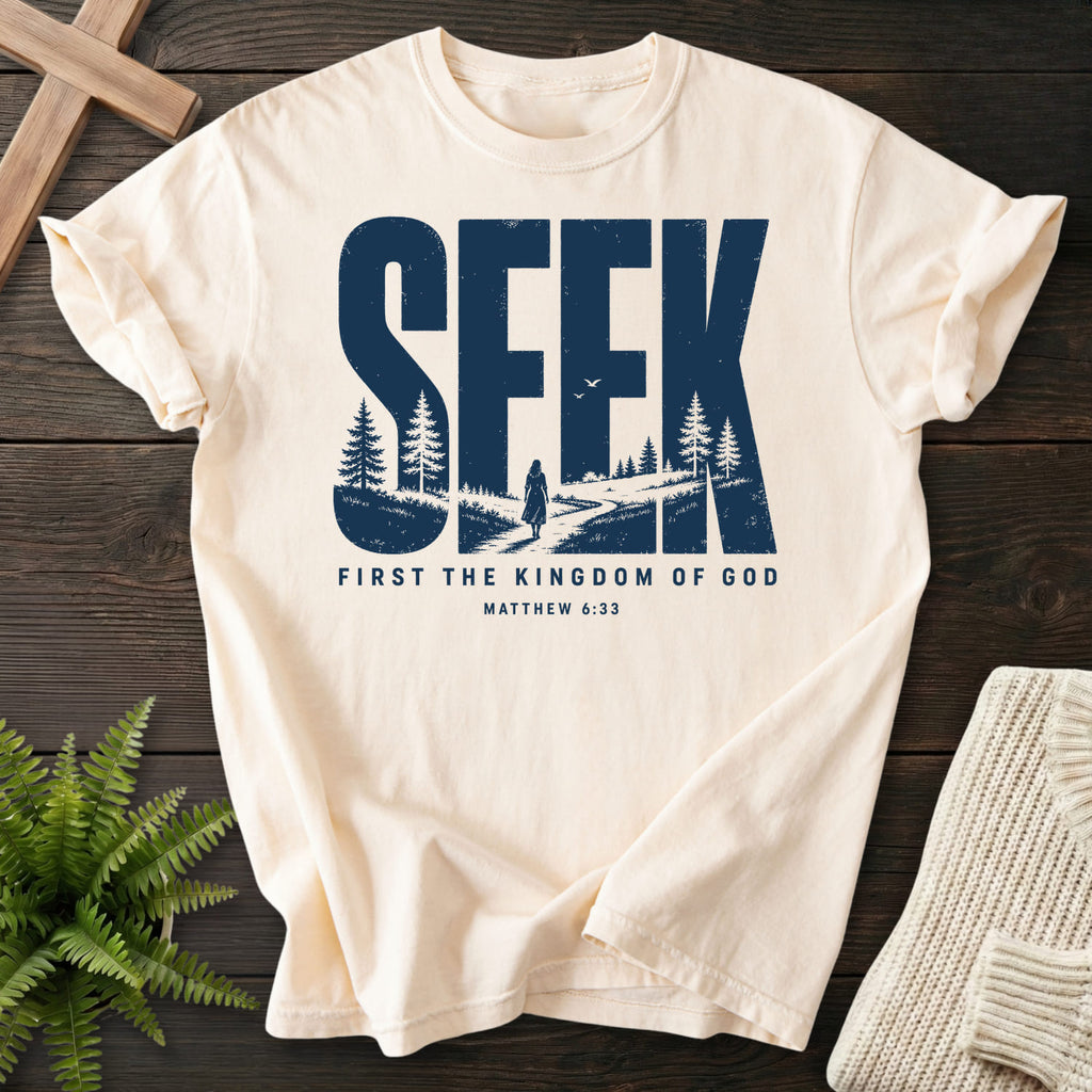 Flat lay of an Ivory Comfort Colors 1717 Christian shirt featuring "Seek First the Kingdom of God T-Shirt" Matthew 6:33.