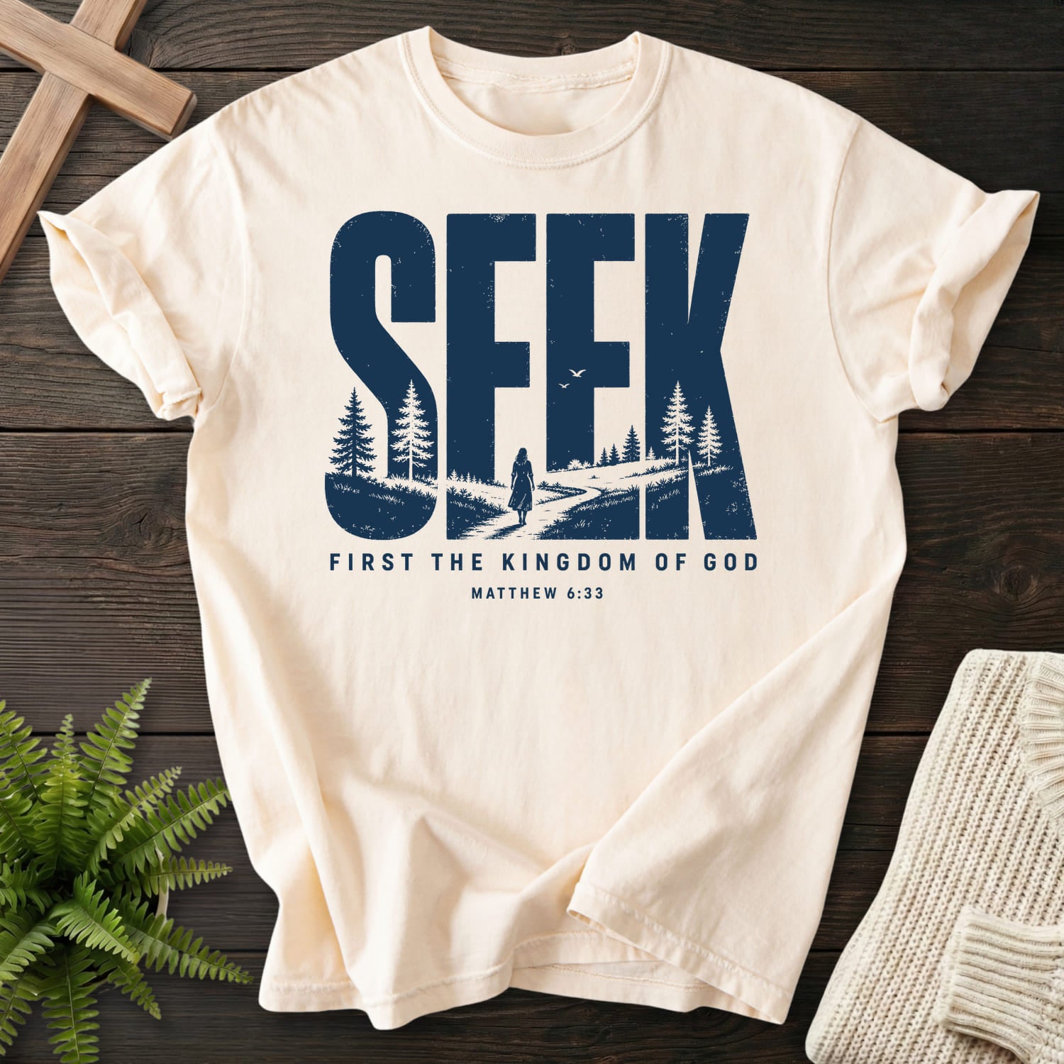 Flat lay of an Ivory Comfort Colors 1717 Christian shirt featuring "Seek First the Kingdom of God T-Shirt" Matthew 6:33.