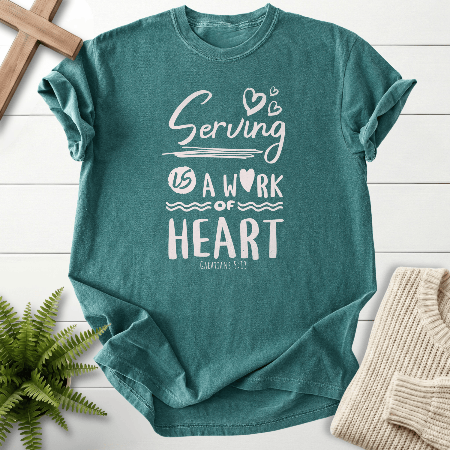 Blue Spruce women's Christian t-shirt with "Serving is a Work of Heart" lettering, inspired by Galatians 5:13.