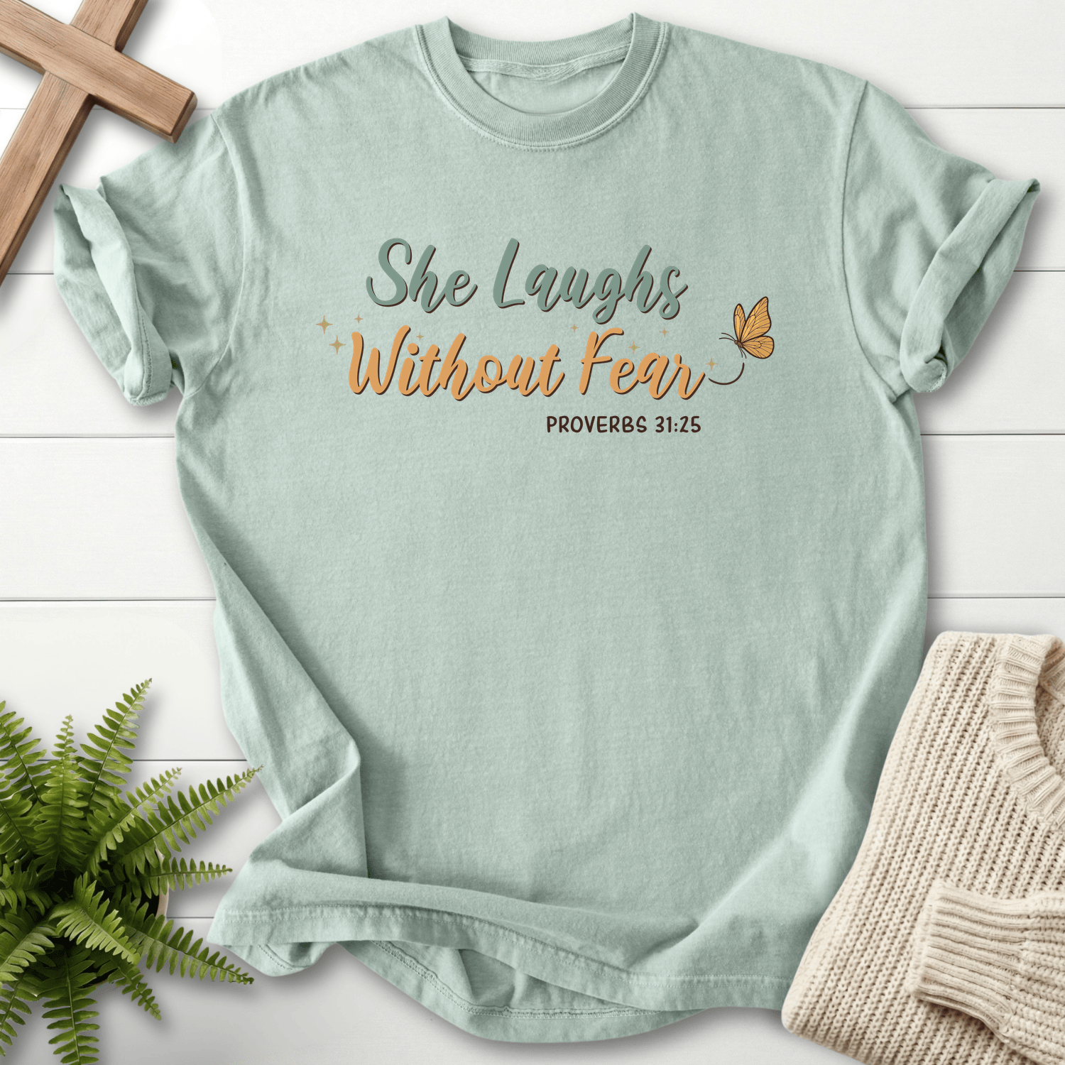 Bay women's faith t-shirt with teal and gold "She Laughs Without Fear" lettering, inspired by Proverbs 31:25.
