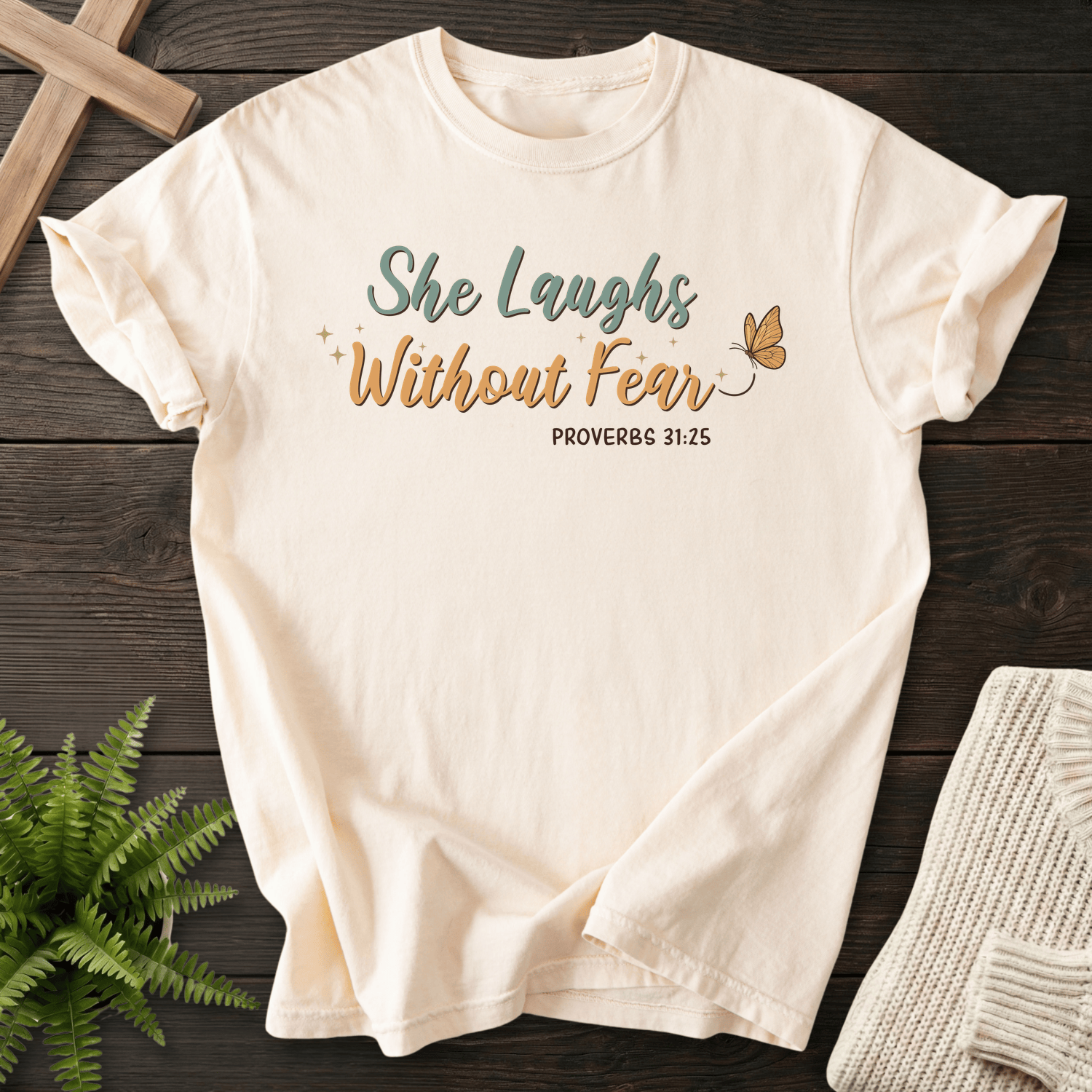 Ivory women's Christian t-shirt with colorful "She Laughs Without Fear" script and butterfly, inspired by Proverbs 31:25.