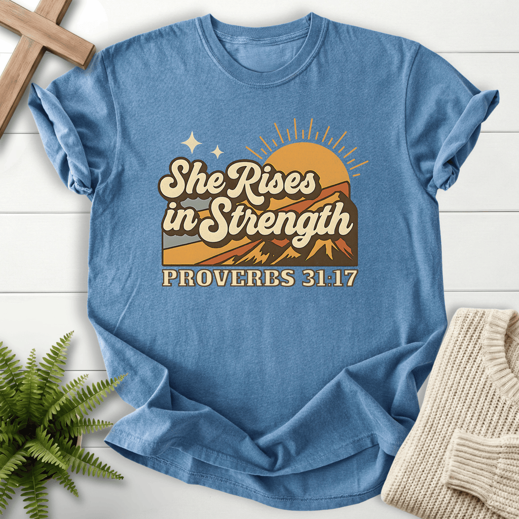 Blue Jean women's Christian t-shirt with retro mountain sunrise and "She Rises in Strength," inspired by Proverbs 31:17.