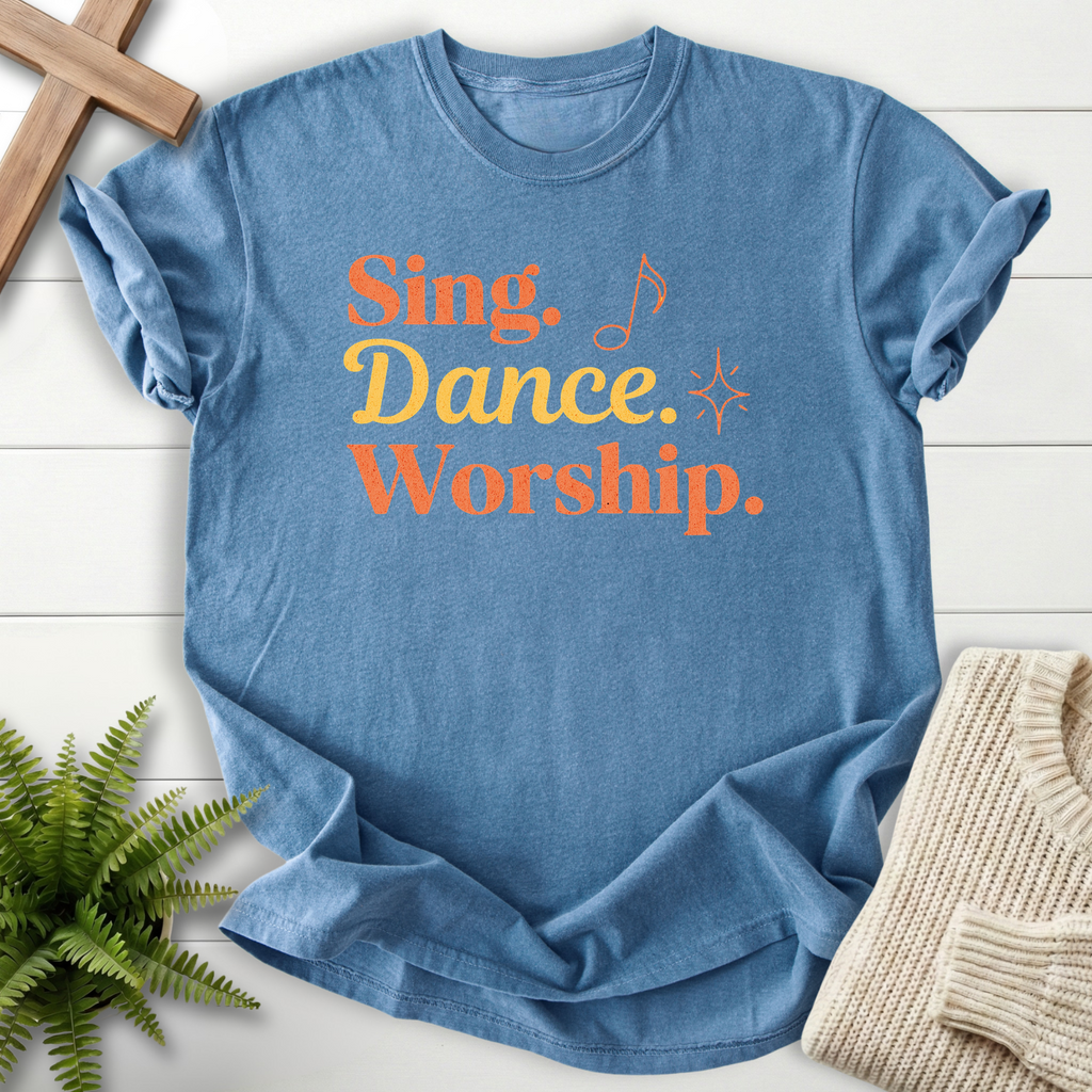 Blue Jean women's Bible verse tee with stacked "Sing, Dance, Worship" lettering and sparkle.
