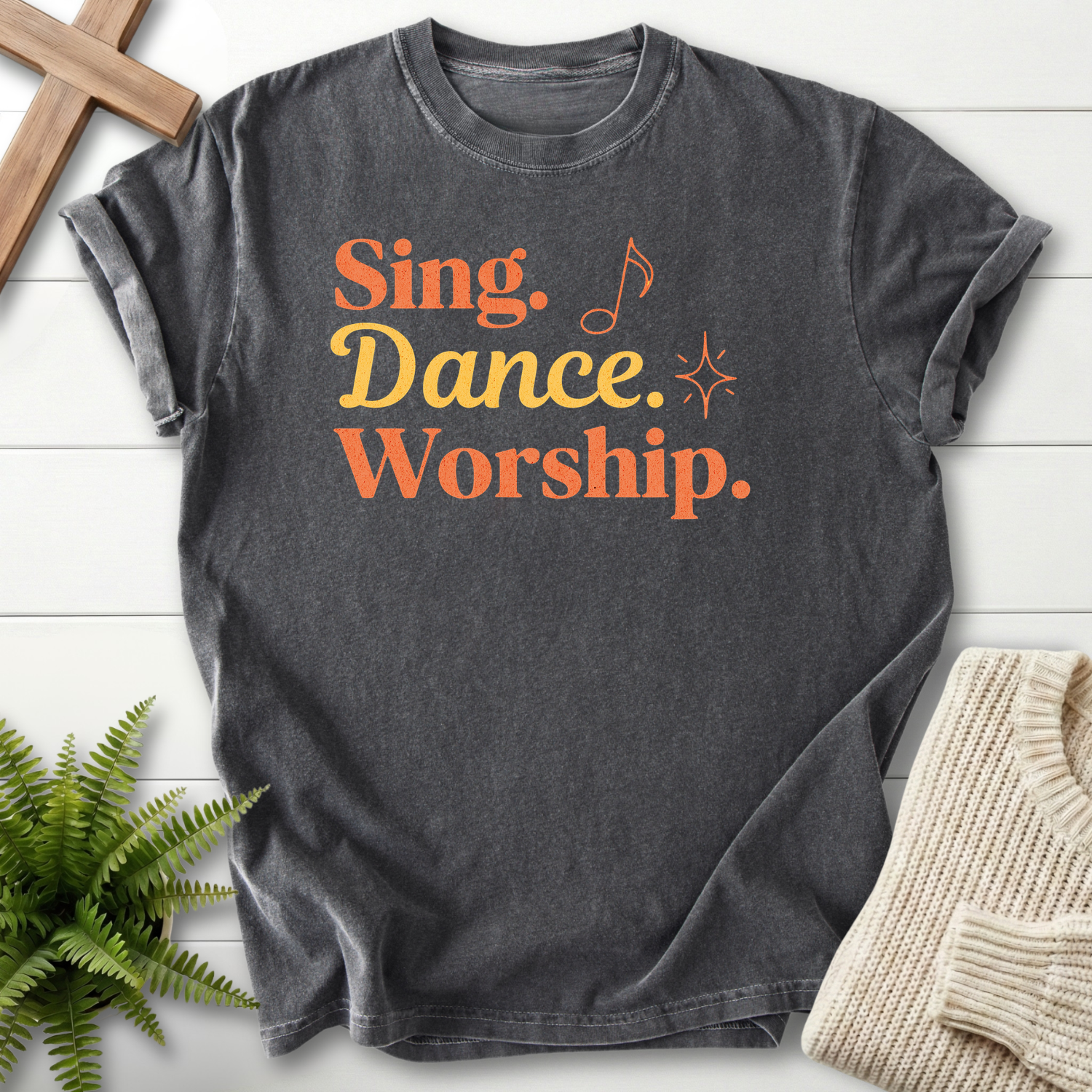 Pepper women's Scripture shirt with bold "Sing, Dance, Worship" in orange retro font.