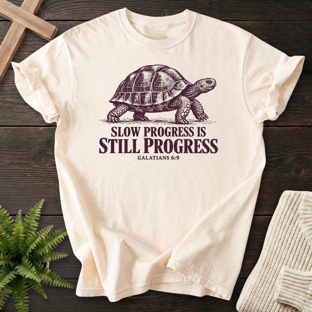 Flatlay of an Ivory women's Christian tee with "Slow Progress Is Still Progress T-Shirt" Galatians 6:9.