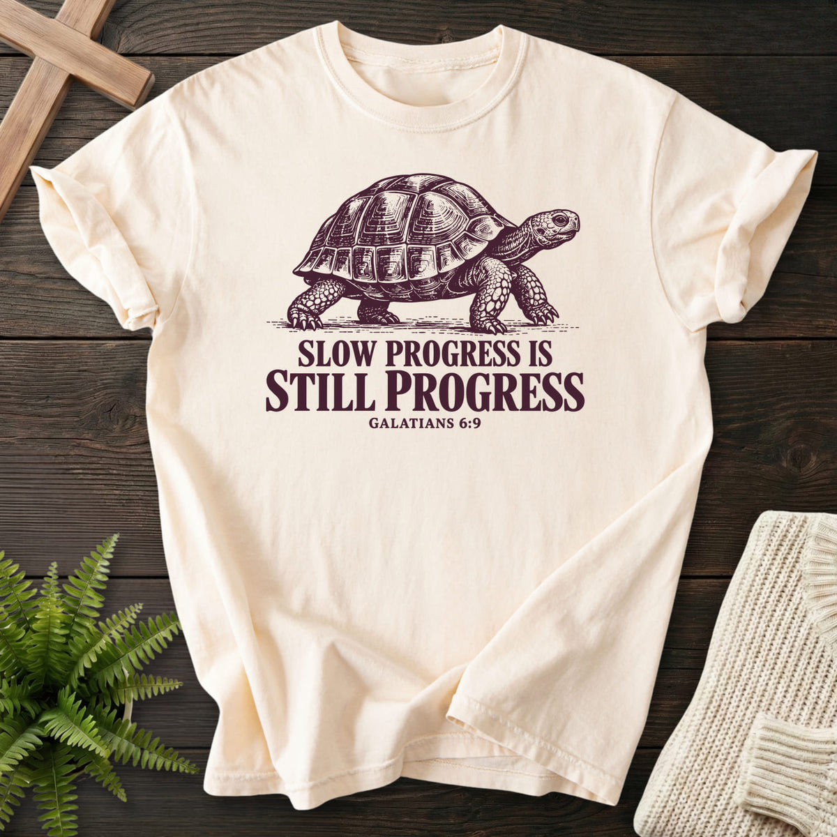Flatlay of an Ivory women's Christian tee with "Slow Progress Is Still Progress T-Shirt" Galatians 6:9.