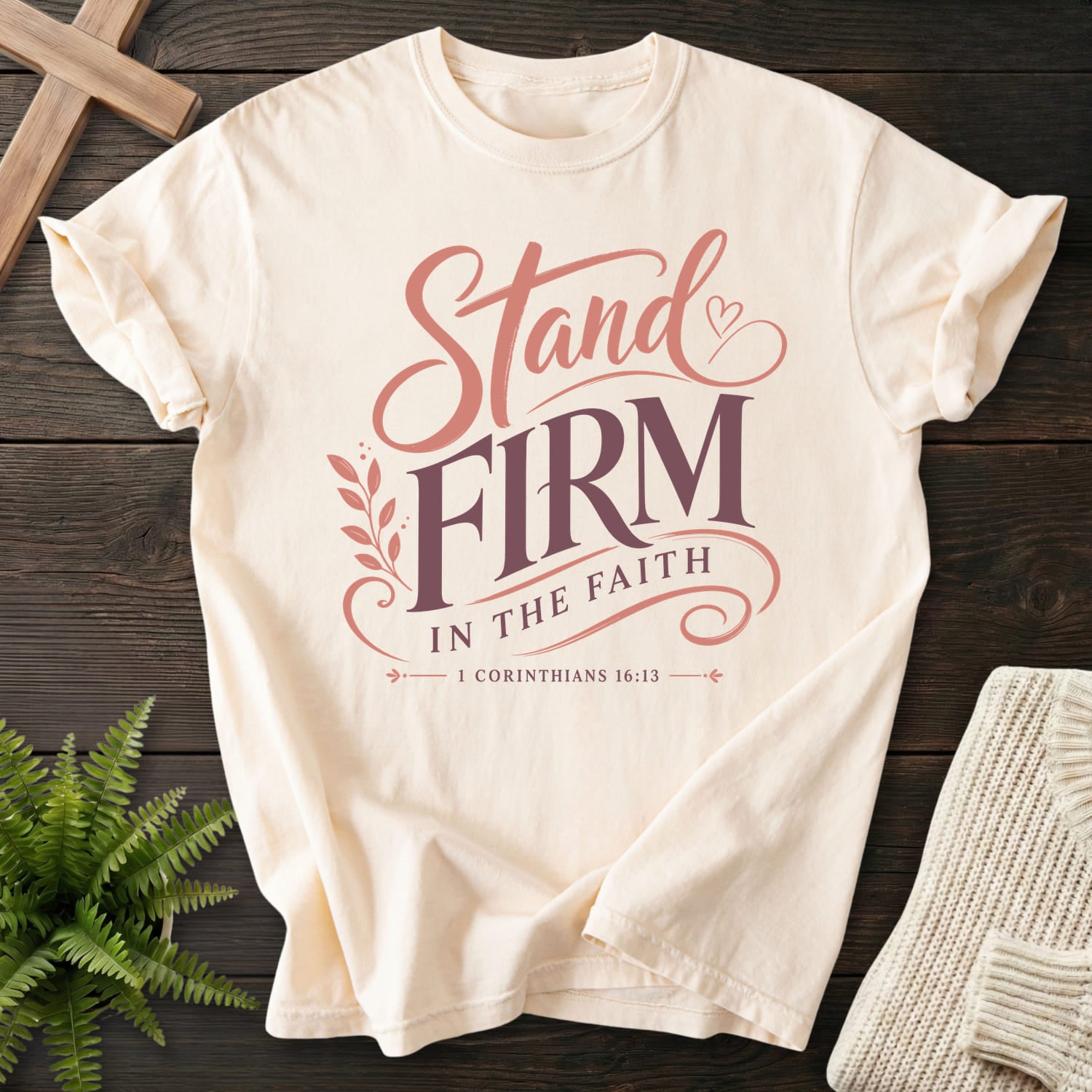 Flat lay of an Ivory garment-dyed Christian tee featuring script typography with "Stand Firm in the Faith T-Shirt" 1 Corinthians 16:13 From Printify.