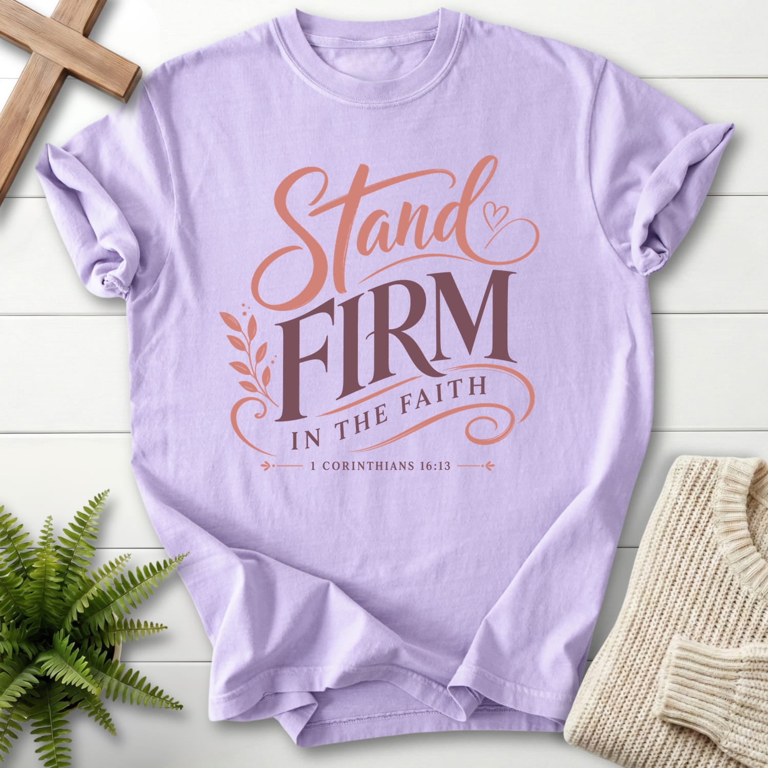 Flatlay of an Orchid Christian graphic tee with script typography with "Stand Firm in the Faith T-Shirt" 1 Corinthians 16:13.