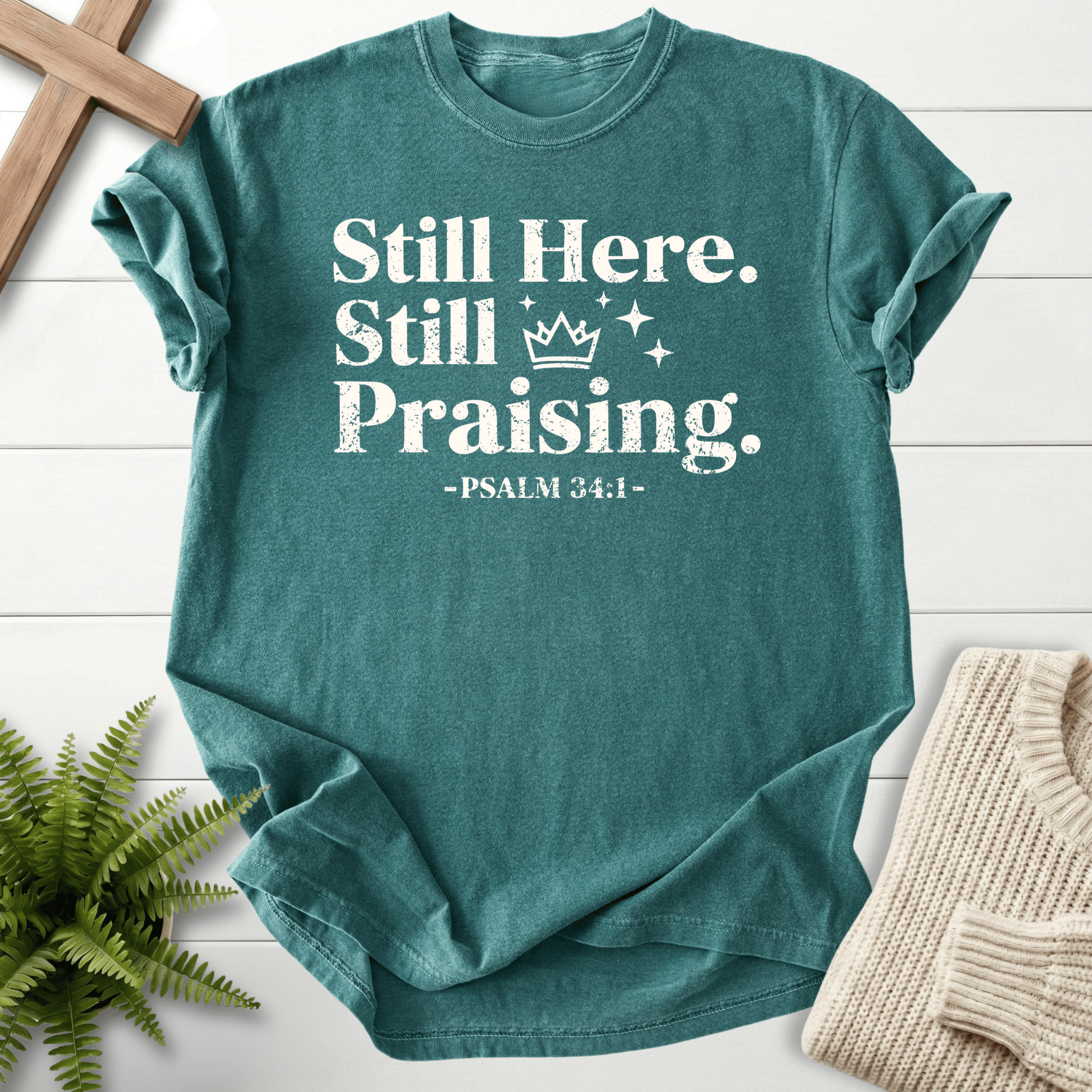 Blue Spruce Christian t-shirt for women with distressed Still Here, Still Praising lettering and sparkle stars, inspired by Psalm 34:1.